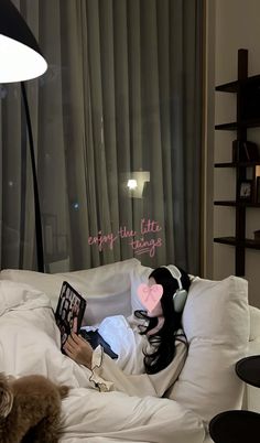 a woman laying in bed reading a book