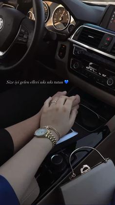 the woman is driving her car and she has on bracelets that are attached to her wrist