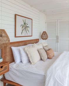 a bed with white sheets and pillows in a room