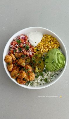 a white bowl filled with rice, beans, avocado and other food items