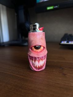 a lighter with an eye and mouth is on the table