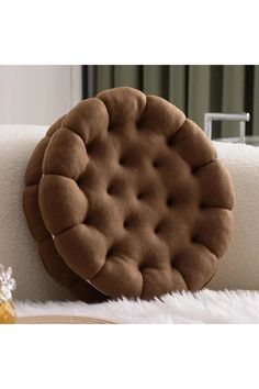 a round pillow sitting on top of a white couch