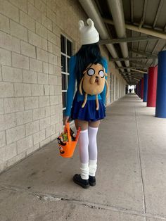 a woman in a blue dress is holding an orange bag