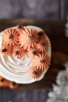 a cake with white frosting and orange flowers on top