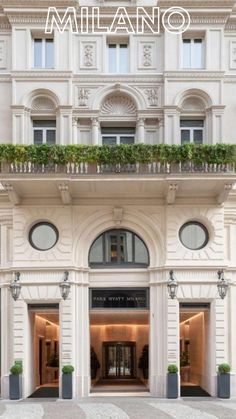 the entrance to a building with plants growing on it's roof and above ground