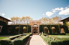 an outdoor courtyard with hedges and trees