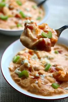 a spoon full of soup with cheese and green onions