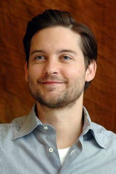 a close up of a person wearing a shirt and tie with a wooden wall in the background