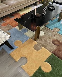 a living room with a couch, coffee table and puzzle pieces on the rugs