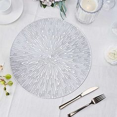 a white table topped with silverware and flowers