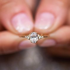 a woman's hand holding a diamond ring