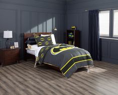 a batman themed bedroom with grey walls and wood flooring