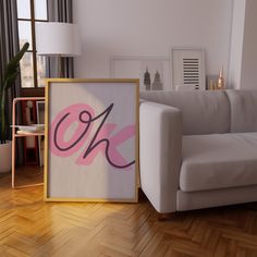 a white couch sitting next to a wooden floor in front of a painting on the wall