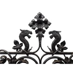 an iron fence with two seahorses on it's sides and one is facing the opposite direction