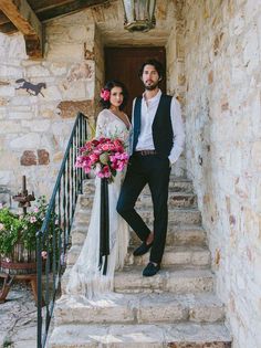 a bride and groom are standing on the stairs