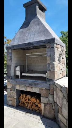 an outdoor pizza oven with wood stacked in it