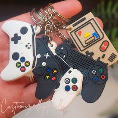 four video game controllers keychains are in the palm of someone's hand