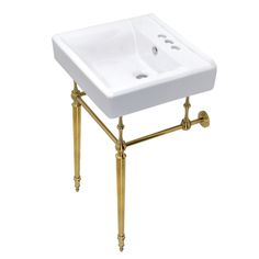 a white sink sitting on top of a gold stand with two faucets underneath it