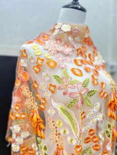 an orange and pink kimono with flowers on it