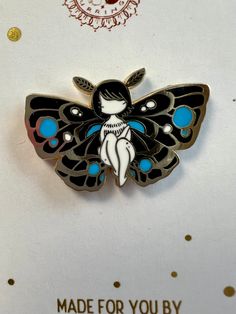 a pin with a black and blue butterfly on it