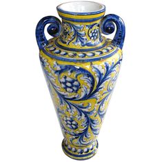 a blue and yellow vase sitting on top of a table