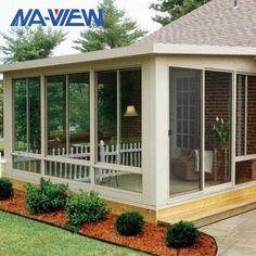 a screened in porch with white railings and landscaping around the patio area is shown