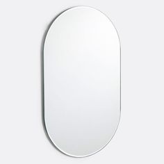 a white oval mirror hanging on the wall