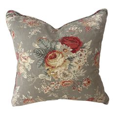 a gray pillow with red and white flowers on it