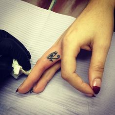 a woman's hand with a small black and white tattoo on the middle finger