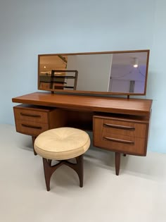 a wooden desk with a mirror and stool