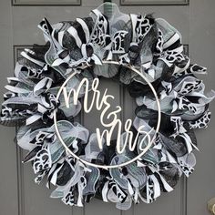 a black and white wreath with the word mr and mrs painted on it's front door