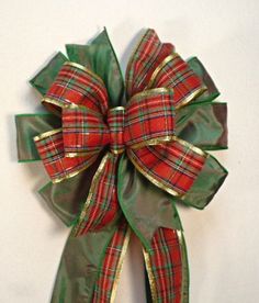 a green and red bow hanging on the wall