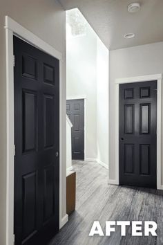 an empty room with two black doors and the words before painted in white on it