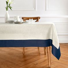 a table with a white and blue cloth on it next to a vase filled with flowers