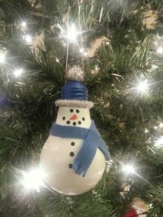 a snowman ornament hanging from a christmas tree