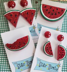 three watermelon slice earrings on top of each other next to a piece of paper