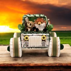 two stuffed animals are riding in the back of a toy car on a wooden table