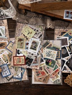 many different types of stamps are scattered on a table with doily and laces