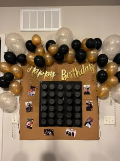 a bulletin board decorated with balloons and photos for a happy birthday party on the wall