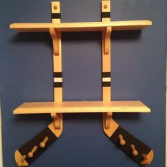 a wooden shelf with two black and white handles on it's sides, in front of a blue wall