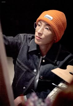 a person wearing glasses and an orange hat