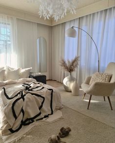 a bed room with a neatly made bed next to a chair and a large window