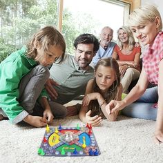 a group of people playing with a board game on the floor in front of a window