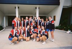 a group of young women standing next to each other in front of a building