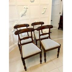 a set of four chairs sitting next to each other on top of a tile floor