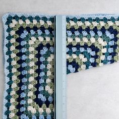 an open crocheted blanket with a ruler in front of it