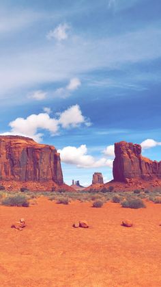 two large rocks in the desert under a blue sky