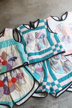 four quilted baby bibs laying on the ground