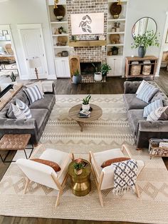 a living room with couches, chairs and a coffee table in front of a fireplace