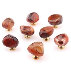 six red and gold glass knobs on white background